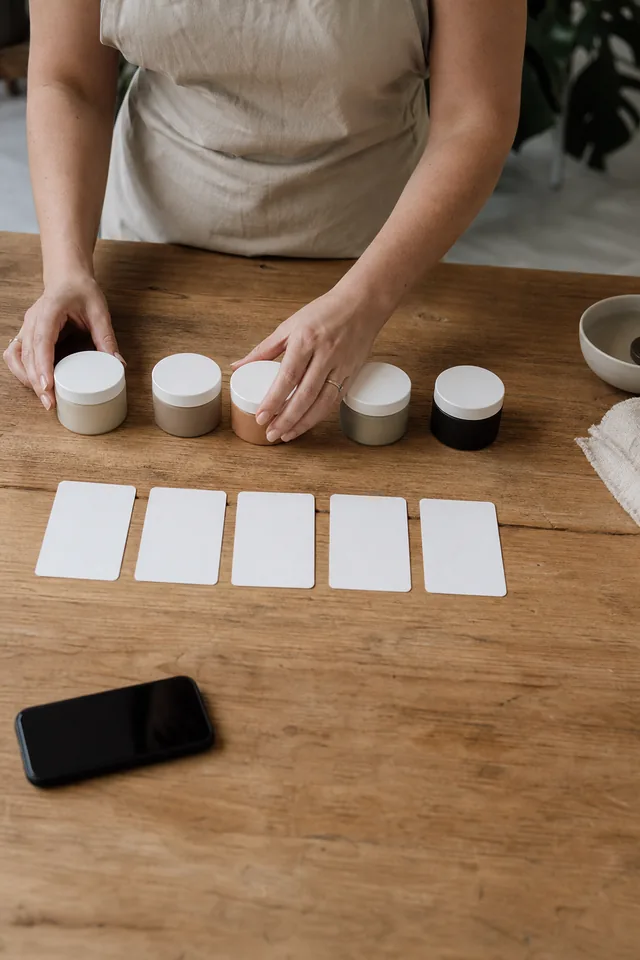 AI-generated editorial photograph of a maker arranging several unbranded product options beside blank comparison cards.